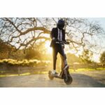 700-12-segwayt-kickscooter-gt-series-lifestyle-picture-man-standing-on-kickscooter-sunlight
